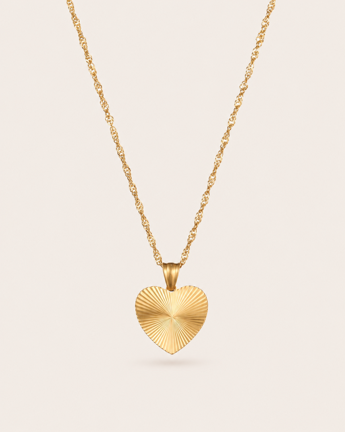 Gold heart pendant necklace with ridged sunburst heart