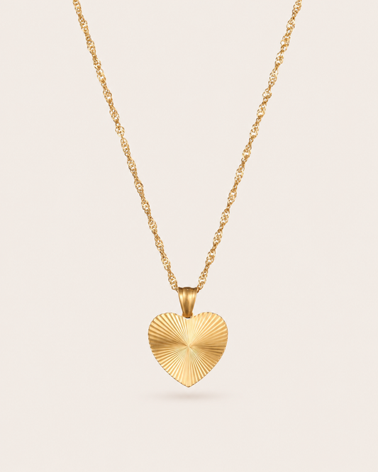 Gold heart pendant necklace with ridged sunburst heart