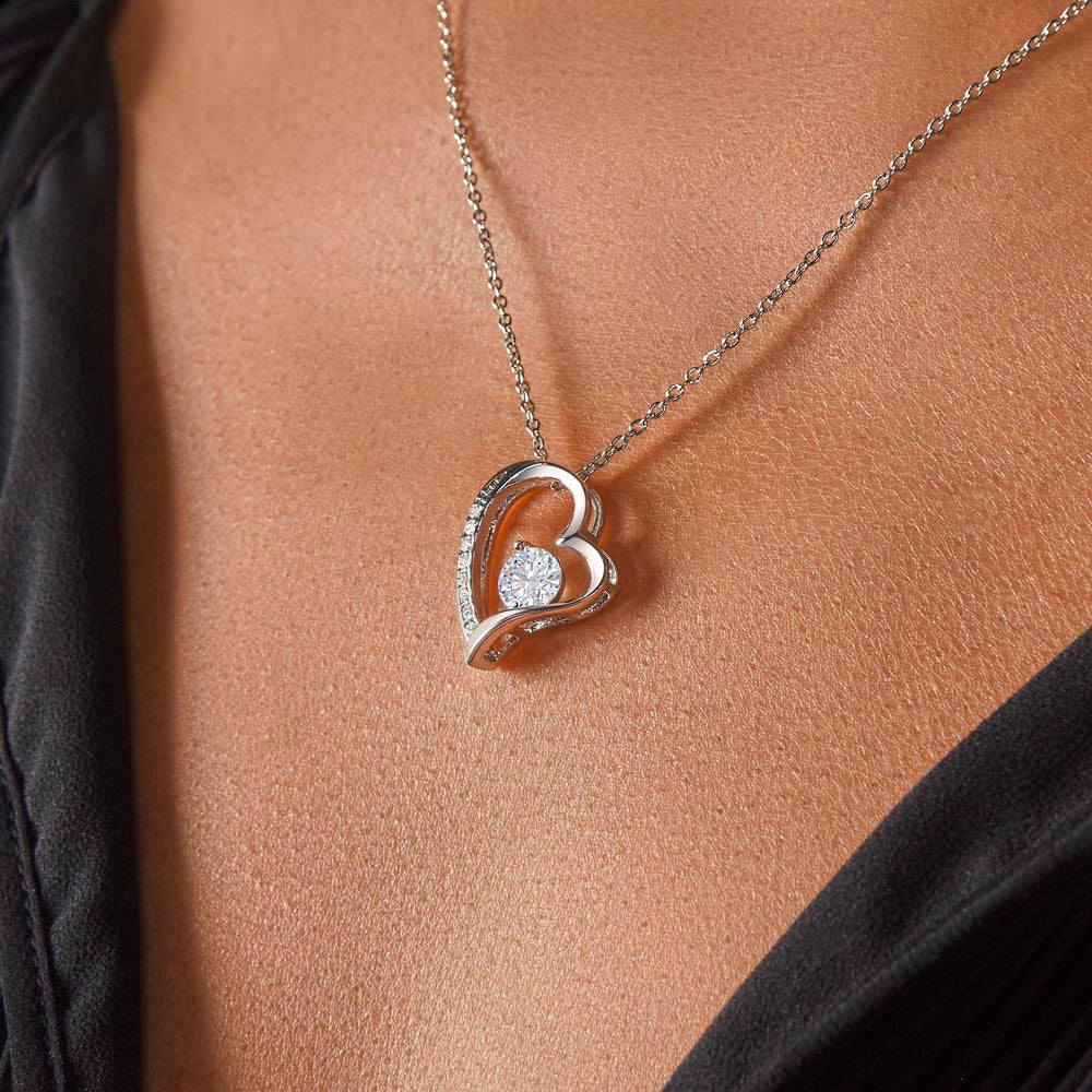 Silver heart pendant with sparkling stone worn below the collarbone
